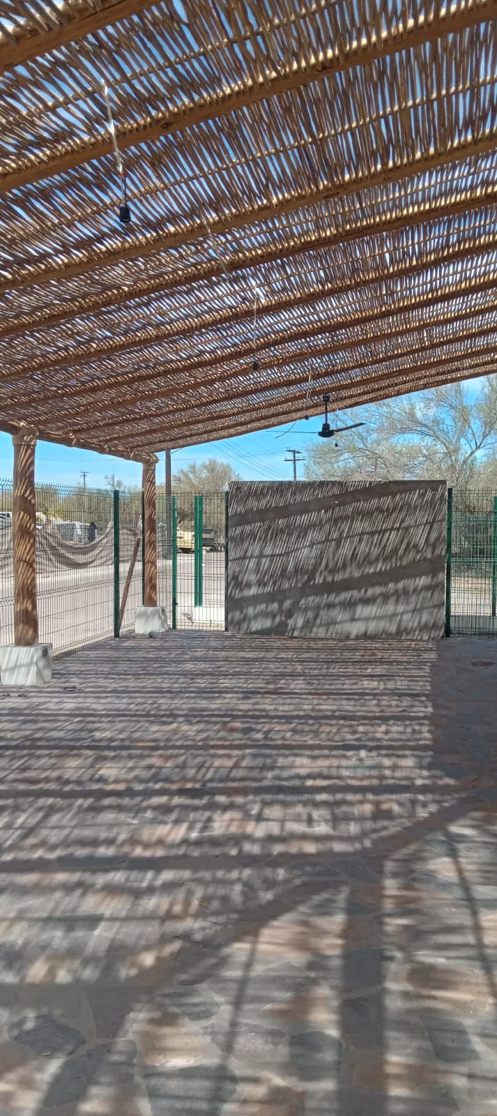 Restaurante TBC — Terraza abierta con ventiladores y muro de concreto aparente