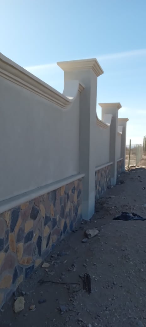 Muro y barda perimetral — Detalle de pilastras, cornisa y remate ondulado